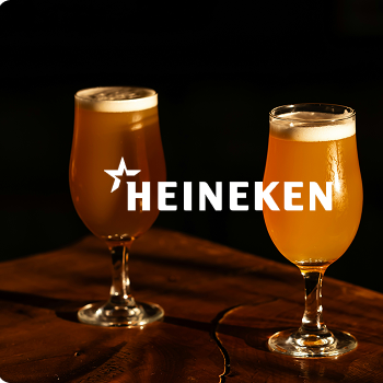 Zwei Biergl&auml;ser mit Schaum auf einem dunklen Untergrund vor schwarzem Hintergrund