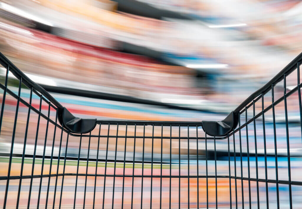 Blick aus einem Einkaufswagen auf verschwommene Regale in einem Geschäft