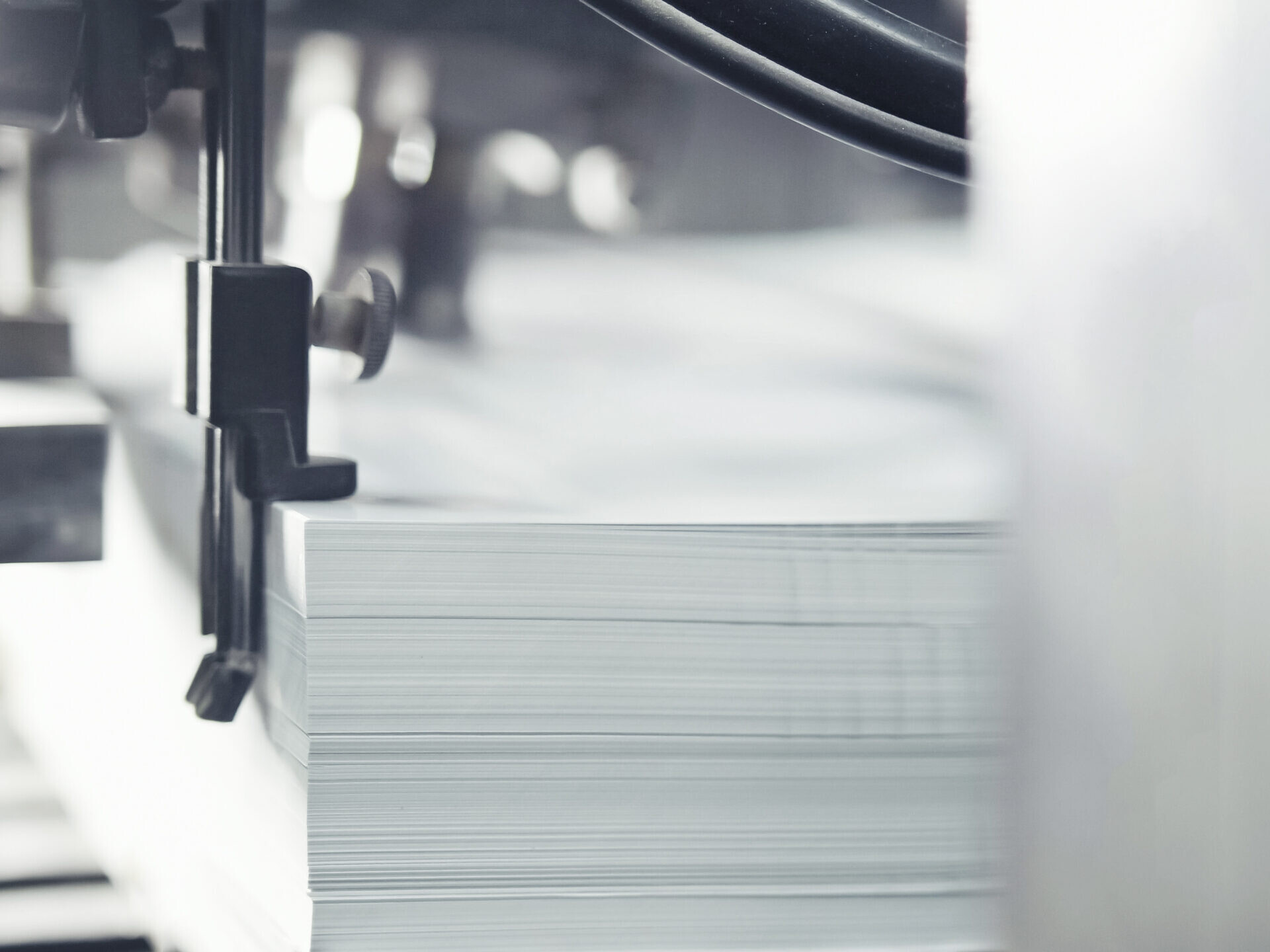 Nahaufnahme eines Stapels wei&szlig;er Papierb&ouml;gen in einer Maschine