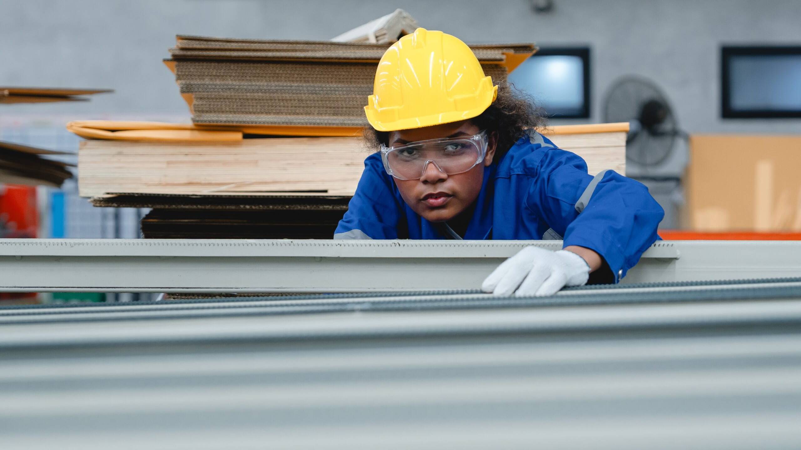 Focused,Female,Technician,Adjusting,Paper,Line,Machinery,In,Cardboard,Factory,