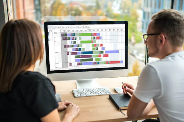 zwei-personen-vor-pc-advanced-planning-scheduling-software